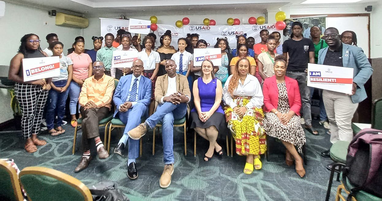 Participants and partners hold I BELONG, I AM EMPOWERED and I AM RESILIENT placards at a MEN Trust event